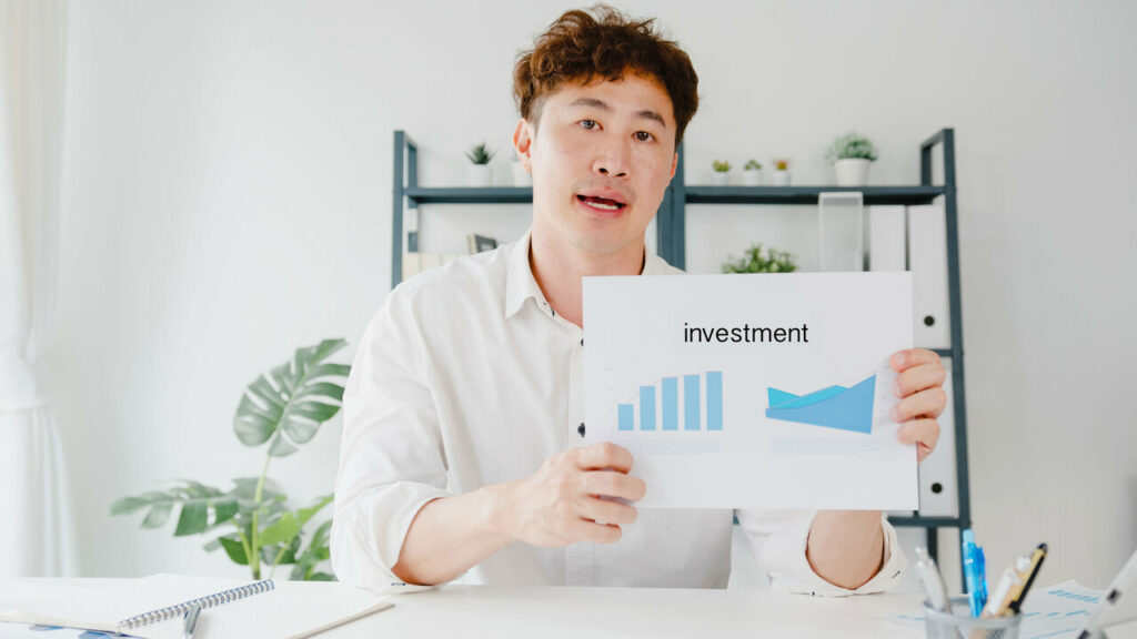 a-man-holding-a-paper-explaining-investment-tips